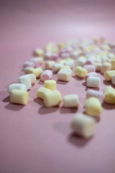 Winzige und farbenfrohe Marshmallows auf pastellrosa Oberfläche — Stockfoto