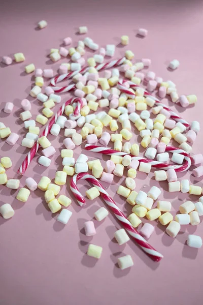 Цветные зефир и конфетки на розовом фоне — стоковое фото