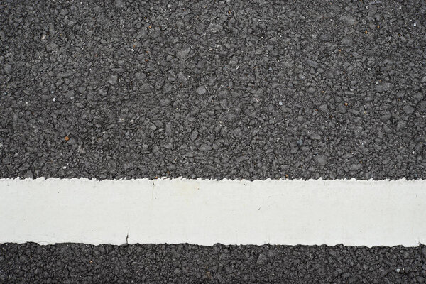 Asphalt road with white dividing stripes.