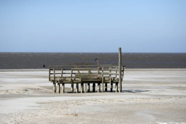 Soğuk ve açık rüzgarlı bir gün bir ağaç yapısı ile büyük sahilde. Sankt Peter Ording Wadden Denizi Alman kısmında.