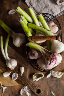 Ahşap arka plan üzerinde bir sepet içinde taze sarımsak