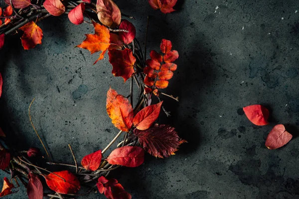 Grinalda feita de ramos e folhas de outono em um fundo cinza . — Fotografia de Stock