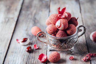 Kırsal ahşap bir taşrada kasede taze organik liçi meyvesi.