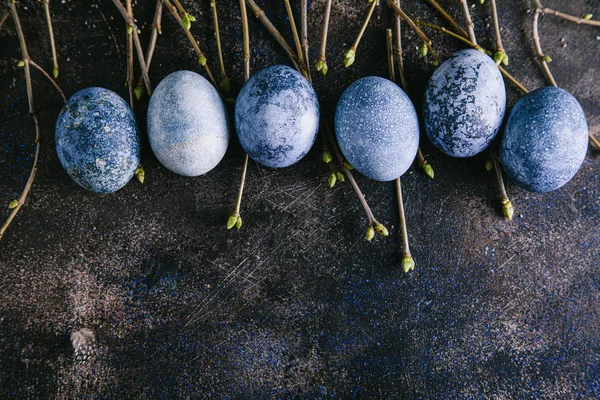 东方快乐的概念 五颜六色的复活节彩蛋涂上了蓝色色调 枝条上的芽呈褐色背景 平面布局 顶视图 复制空间 — 图库照片