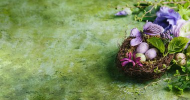 Mutlu Paskalyalar. Çok renkli paskalya yumurtaları ve dalları yeşil arka planda tomurcuklanmış. Kapat, boşluğu kopyala.