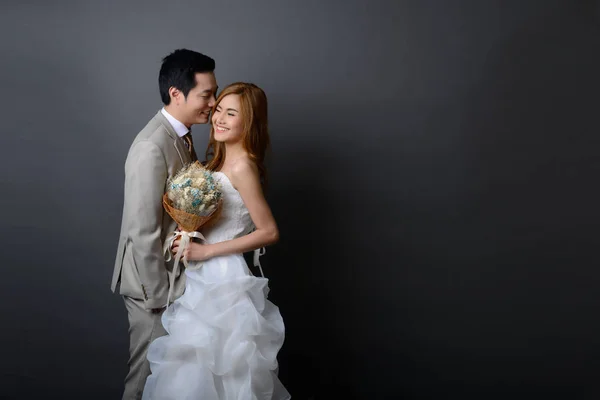 Joven asiático novio y novia posando y sonriendo en estudio para pre Imagen De Stock