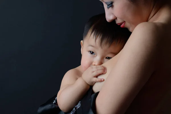 Asian mother holding and breast feeding her baby — Stock Photo, Image