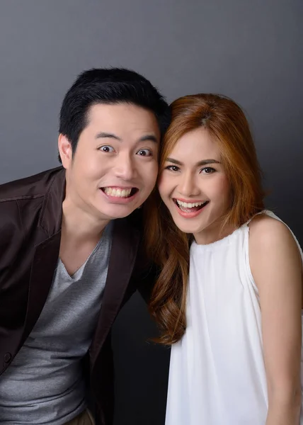 Portrait of young asian couple laughing on gray background — Stock Photo, Image