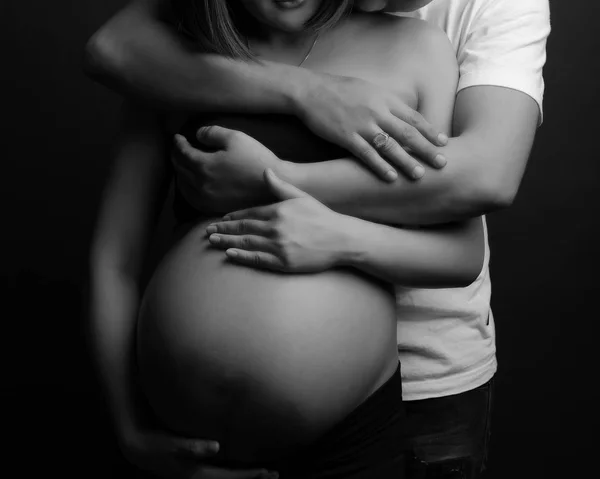 Abrazo de hombre en el vientre de la mujer embarazada, concepto de familia Imagen De Stock