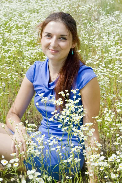Krásná žena na poli heřmánek — Stock fotografie