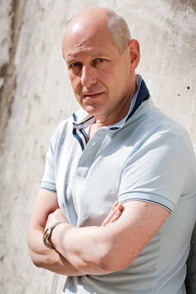 Homme d'âge moyen aux cheveux gris en T-shirt bleu avec bras croisés — Photo