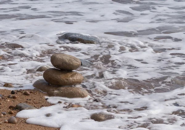 Okyanusun kenarında yığılmış üç küçük taş