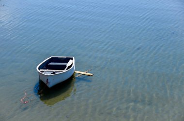 Yalnız beyaz kayık negatif boşluk ile sakin mavi su