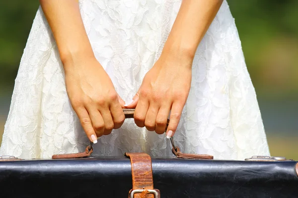 Gyönyörű a kezében tartja a bőrönd — Stock Fotó