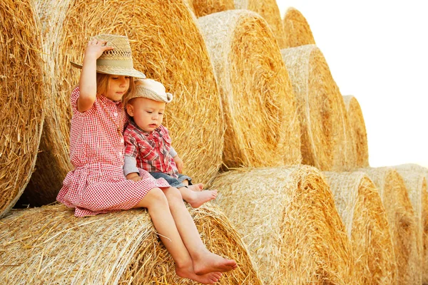 Happy children on a field with bales harvest — Stock Photo, Image