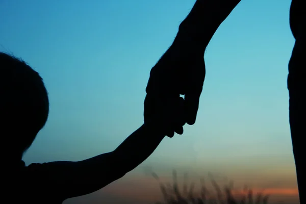 Padre con le mani del bambino silhouette — Foto Stock