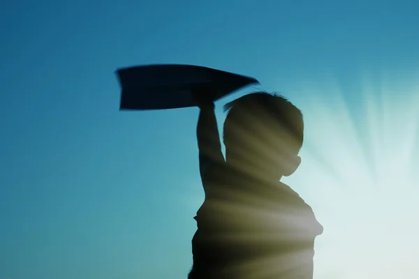 Kind silhouet die kartonnen vliegtuig — Stockfoto