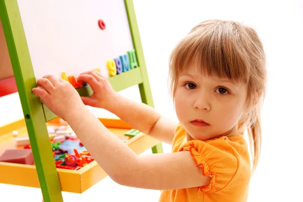 Jeune fille jouant avec des lettres et des chiffres — Photo