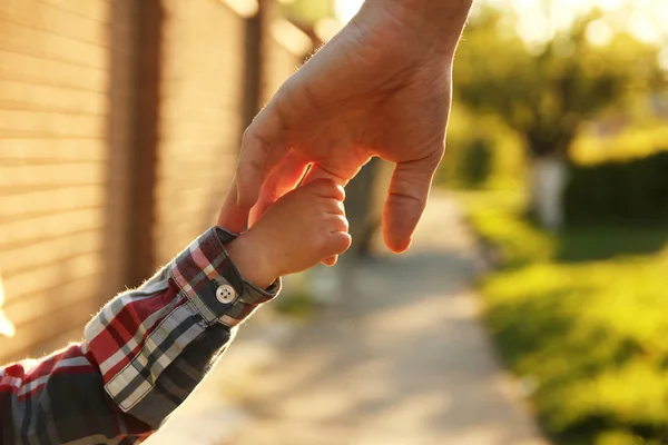 father holding hand of child