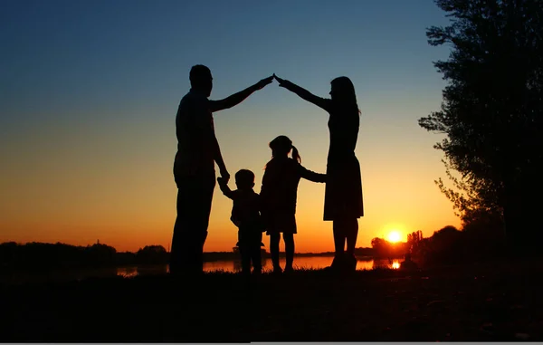 Silhouettes of happy family — Stock Photo, Image