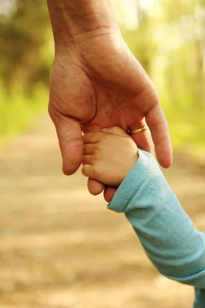 Родитель держит за руку ребенка — стоковое фото