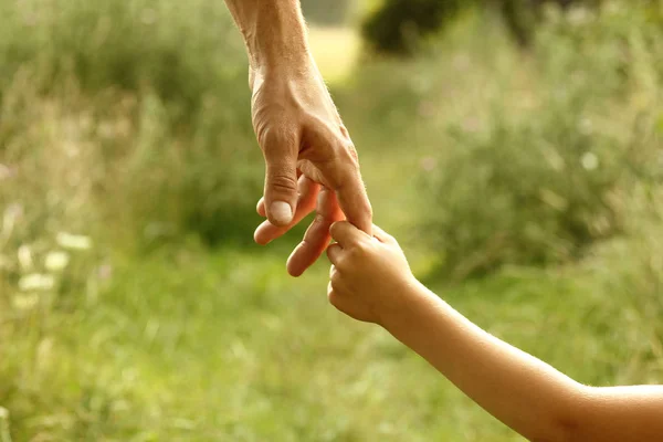 Bovenliggende houdt de hand van een kind — Stockfoto