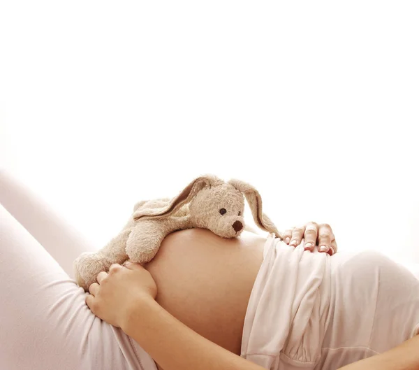 Zwangere vrouw met speelgoed op buik — Stockfoto