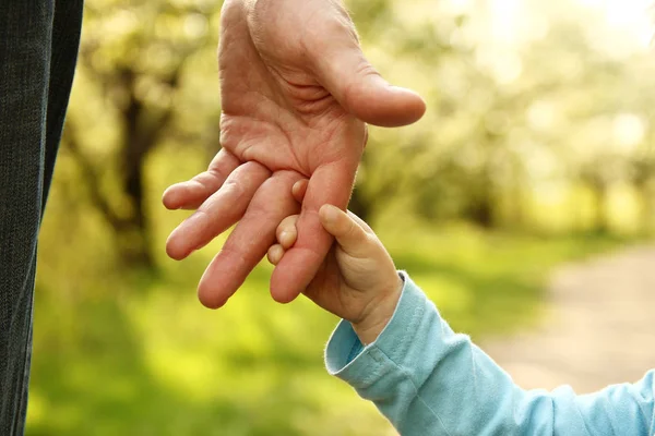 Bovenliggende houdt zorgvuldig hand van kind — Stockfoto