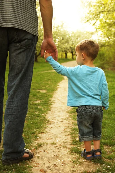 Padre sostiene cuidadosamente la mano del niño —  Fotos de Stock