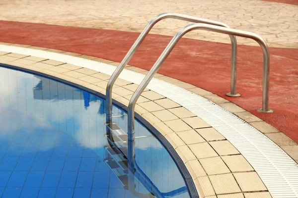 Corrimão metálico na piscina de água azul — Fotografia de Stock