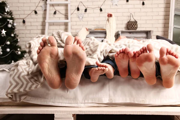 Feet of family poking out from under blanket — Stock Image Feet of family poking out from under blanket Royalty Free Stock Images