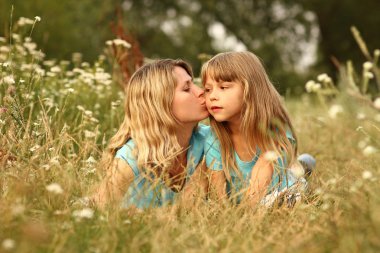 küçük kızı çim üzerinde yalan öpüşme anne