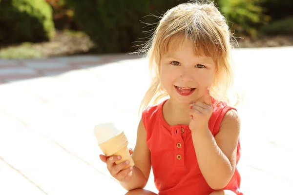 公園の自然の中でアイスクリームを食べる幸せな子供 — ストック写真