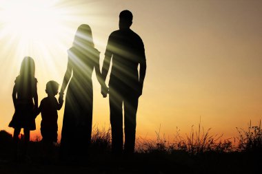 Günbatımında niteliğine mutlu bir aile silüeti 
