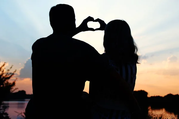 Silueta de pareja feliz en la naturaleza de fondo puesta de sol —  Fotos de Stock