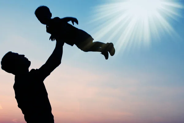 Glücklicher Vater mit Baby-Silhouette in einem Park in der Natur — Stockfoto