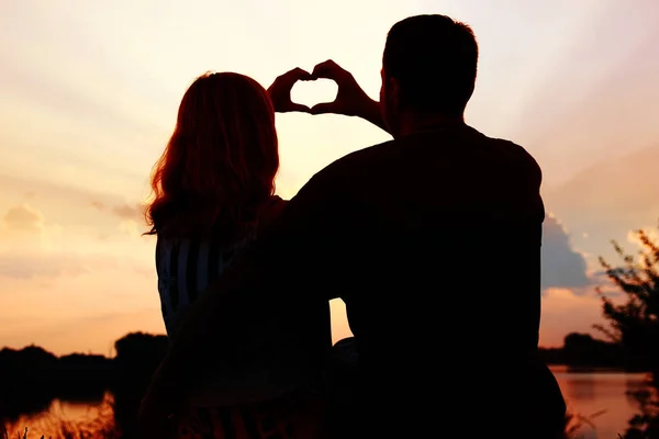 Silueta de pareja feliz en la naturaleza de fondo puesta de sol — Foto de Stock