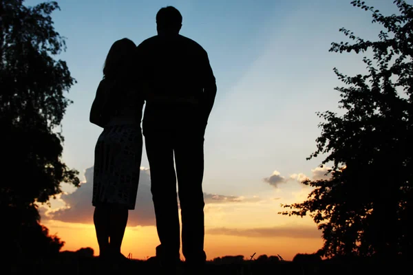 Ευτυχισμένο ζευγάρι μαζί στο ηλιοβασίλεμα σιλουέτα της φύσης — Φωτογραφία Αρχείου