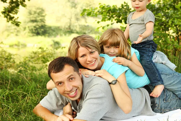 Familia al aire libre jugando en el parque en la hierba — Foto de Stock