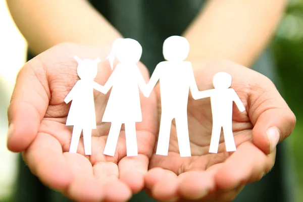 In the hands of the family on a background paper — Stock Photo, Image