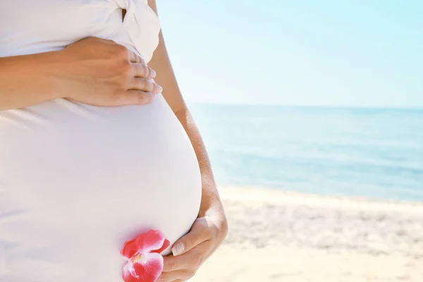 Gelukkig mooie zwangere vrouw aan de zee in de zomer op de n — Stockfoto