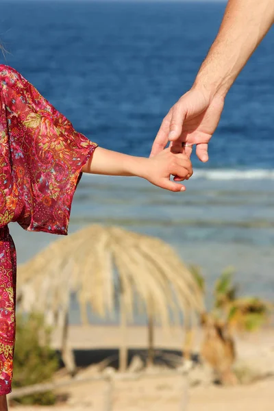 Parent holds the child's hand on the sea — Stock Photo, Image