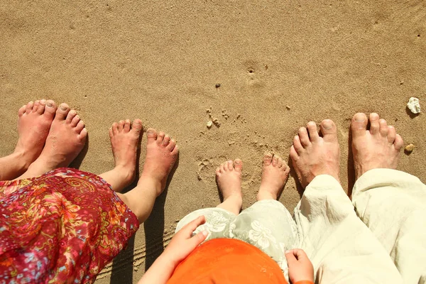 Pés de família na areia na praia — Fotografia de Stock