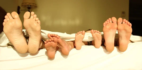 Los pies de la familia en la cama —  Fotos de Stock