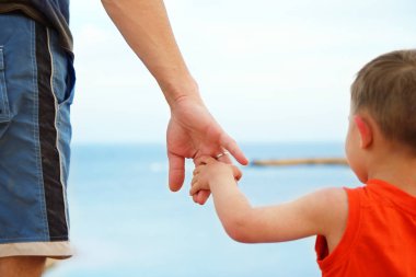 ebeveyn çocuğun el sahilde tutar.