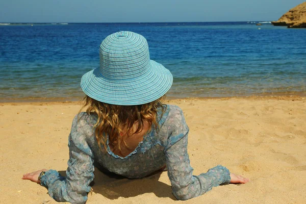 Jonge vrouw met hoed aan de kust — Stockfoto