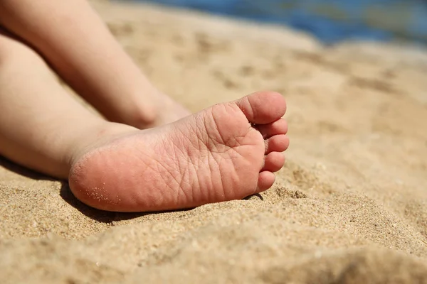 Pernas de uma criança na areia — Fotografia de Stock