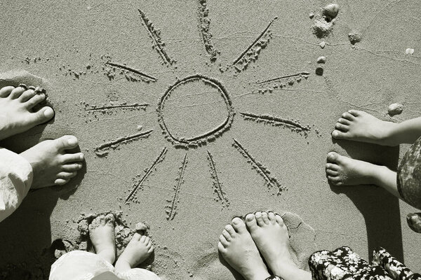 Family feet on the sand on the beach
