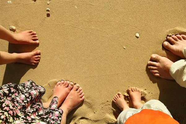 Les pieds en famille sur le sable sur la plage — Photo