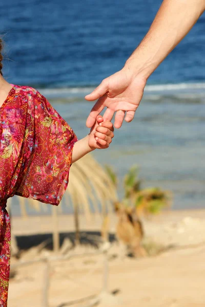 Moderbolaget innehar barnets hand på stranden — Stockfoto